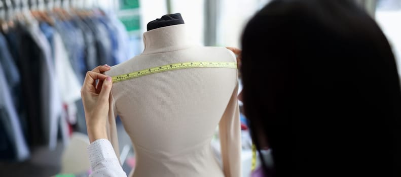 Close-up of female fashion designer takes measurements with centimeter. Tailor woman sewing fashion clothes. Designer, art and sewing concept