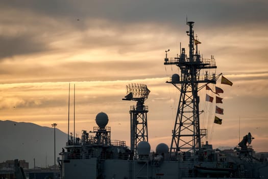Close-up of parabolic satellite dishes and intricate metal structure, part of a communications tower set against a grey overcast sky download image