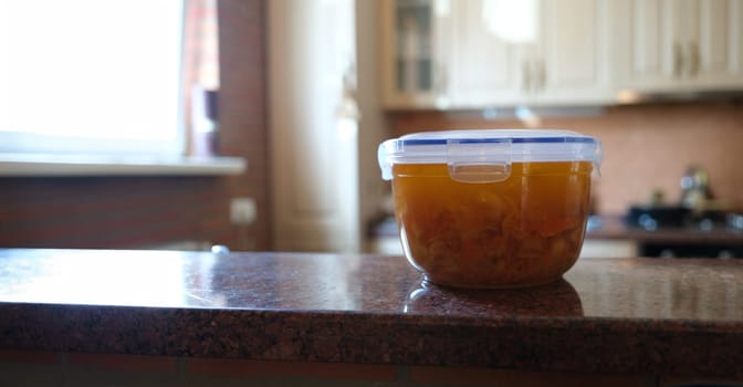 Close-up of plastic container with freshly prepared soup, food to go. Transparent lunchbox with bouillon. Healthy eating and lifestyle concept