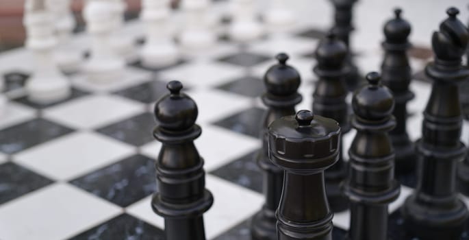 Close-up of chessboard with chessmen, chess battle white against black. Board and strategy game. Creative teamwork company business concept