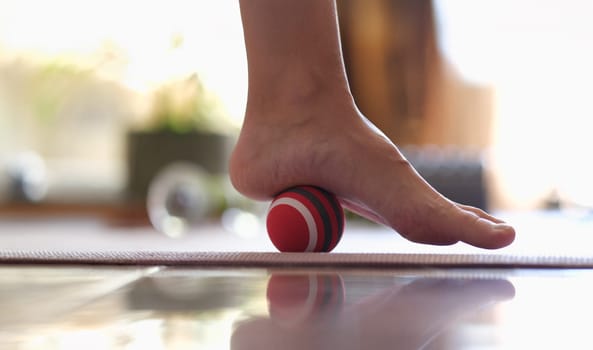 Close-up of myofascial release of hyper-movable muscles of foot with massage ball. Prevention of leg fatigue and foot disease concept