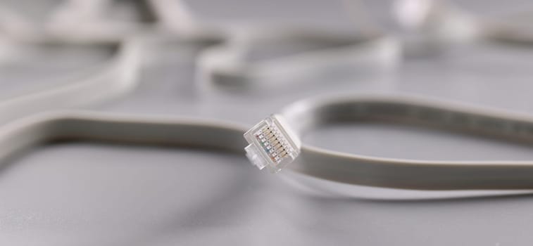 Close-up of internet connectors on grey background, cable with plastic clip. Internet and telecommunications, modern technology and service concept