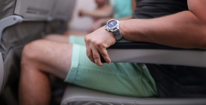 Close-up of scared man strongly grab armrest in plane. Airplane and panic. First flight and fear of heights concept