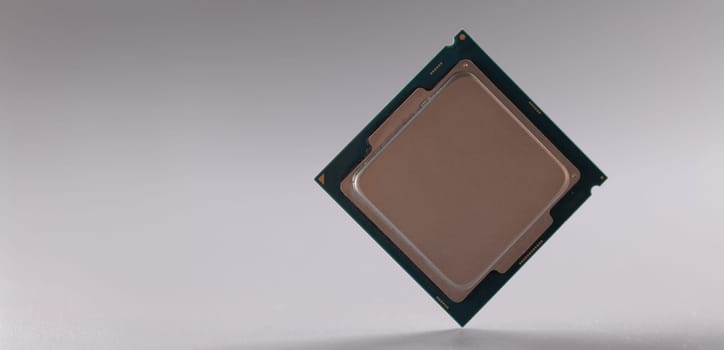 Close-up of central processing unit, processor chip on grey background. Chipping and microcircuits, modern technology and innovation concept