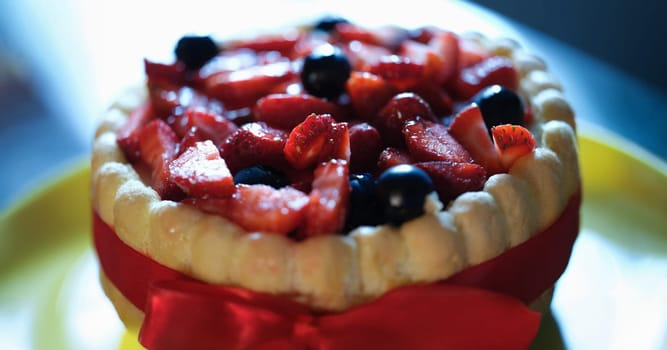 Close-up of tart with berries and custard, festive cake. Summer fruit baking concept. Pie with strawberry and blackberry