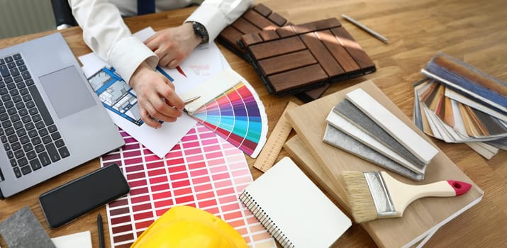 Top view of interior designer working at project, palette on workplace. Selection of material colour from samples. Design studio and architect concept