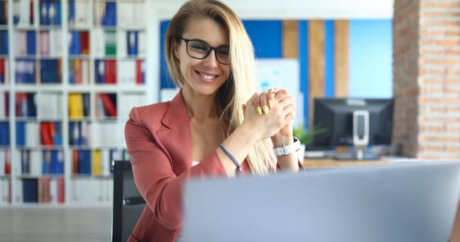 Portrait of smiling woman communicating via video call on laptop. Business coach at online seminar showing support gesture. Training, coaching concept
