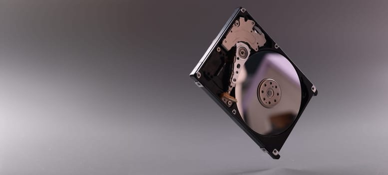 Close-up of computer hard disk drive with open cover. Hardware, hard disk and storage device. Detail of inside of hard disk drive