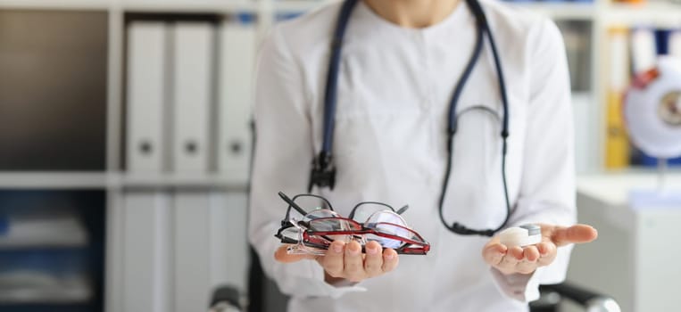 Close-up of female doctor making choice between contact lenses and glasses. Ophthalmologist, ophthalmology and vision correction concept