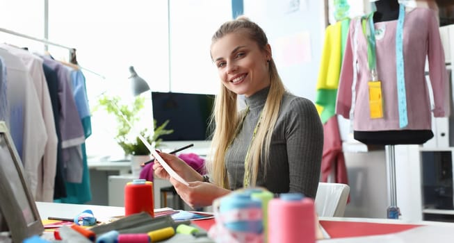 Portrait of smiling sewer designing new fashion collection in atelier. Professional designer and premium quality clothes. Sewing creating new brand concept