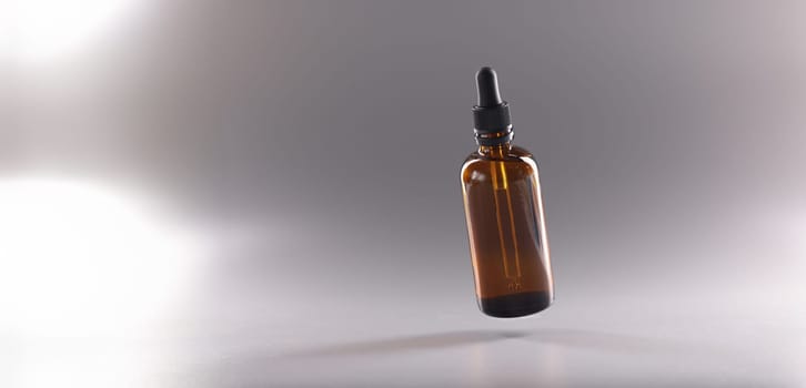 Close-up of glass bottle filled with liquid, flask with cosmetology or medical product. Moisturizer lotion or oil for body and face. Cosmetology and wellness