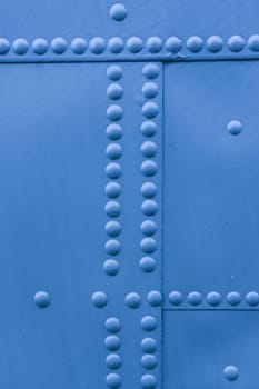 Protection of military equipment made of sheet metal with blue rivets.
