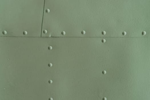 Protection of military equipment made of sheet metal with green rivets.