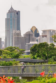 Bangkok, Thailand - 22 Jun, 2024 - Architecture view of Modern high-rise buildings on blue sky background and Benjakitti park skywalk in front. Picturesque cityscape view, Copy space, Selective focus.