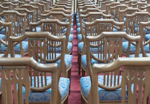Bangkok, Thailand - May 22, 2024 - Perspective view of Wooden chairs with cushion seat for sitting within Samphanthawong Saram Worawihan temple. Space for text, Selective focus.