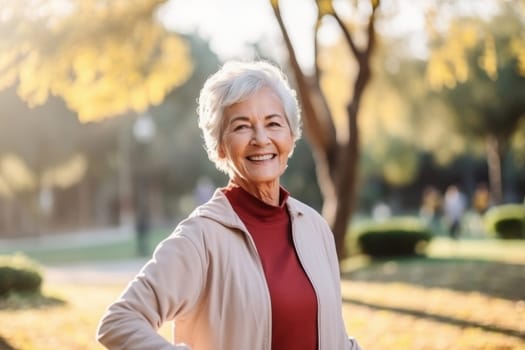 Portrait of happy and healthy senior woman smiling in autumn park. Active and healthy lifestyle for elderly people.