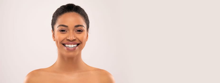Cheerful millennial african american lady with nude makeup looking at camera, isolated on studio background, studio, close up. Beauty and skin care at home, cosmetology, fashion, copy space