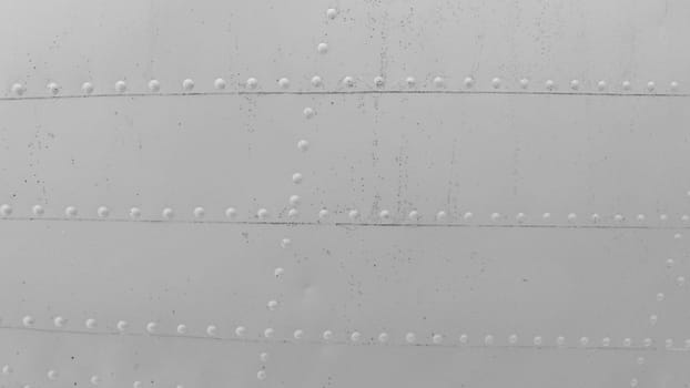 Photo of the metal skin of an old aircraft with rivets.