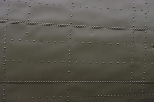 Fragment of an airplane side with rivets.