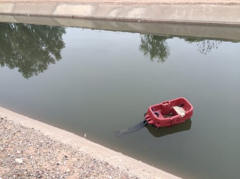 Plastic Red Wagon Floating in the Canal in Mesa, Arizona. High quality photo