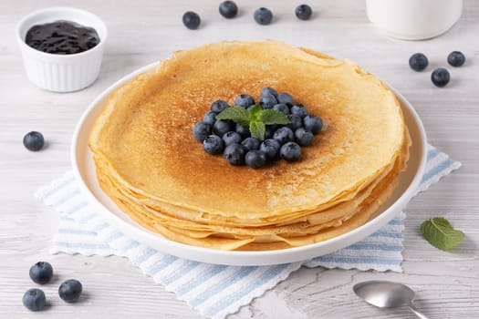 Crepes, thin pancakes with blueberry jam and fresh berries.