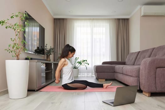sporty woman stretching hands and warm up arm for exercise at home, online training