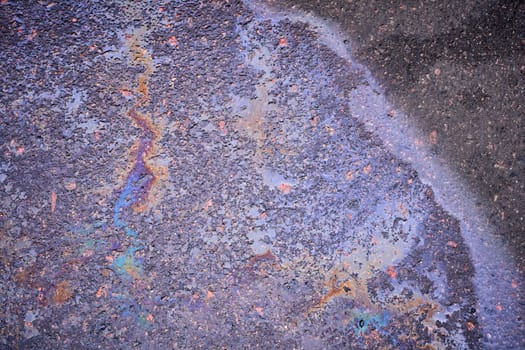 Drops of gasoline or diesel fuel on an asphalt surface serve as a textured background
