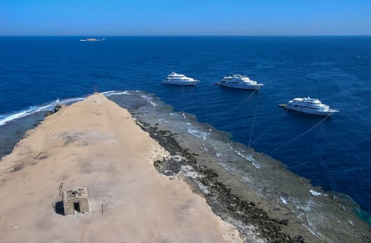 Big Brother Island, Egypt - November 10, 2004: tourist yachts near the coastal reef of Big Brother Island in the Red Sea, Hurghada area