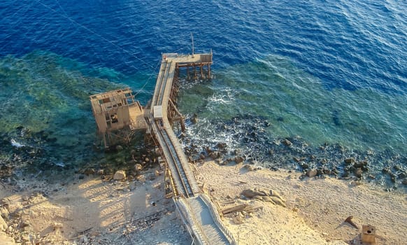 Big Brother, Egypt - October 26, 2008: antique iron and wooden pier in front of the lighthouse on Big Brother Island, Red Sea, Egypt