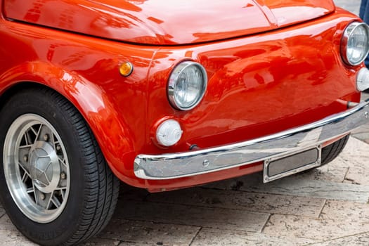 Close-up of a vintage red car with chrome details and retro design