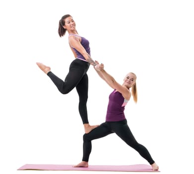 Sporty girls in violet tops and black leggings training together in studio