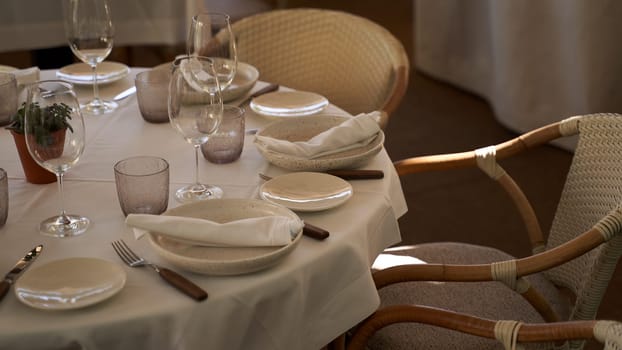 Spanish outdoor restaurant. Cozy served tables and wicker chair on a sunny evening.