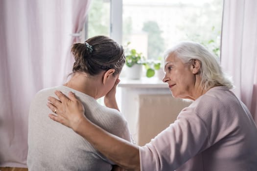 Aged mom encourage beloved adult girl child in difficult life situation.