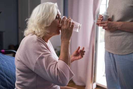 senior woman with glass water and pills. High quality photo