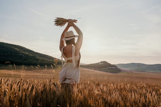 A woman in a white dress and hat holds a bundle of wheat while standing in a field of tall grass, looking towards a distant hill.