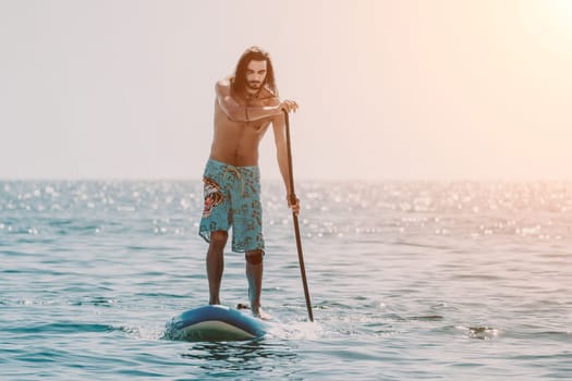 Man Sea Sup. Strong athletic man learns to paddle sup standing on board in open sea ocean on sunny day. Summer holiday vacation and travel concept. Aerial view. Slow motion.