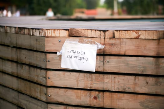 the inscription in Russian is forbidden to swim. Warning. Danger.Outdoor swimming pool.
