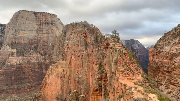 Beautiful shot of the famous Angels Landing rock formation and narrow hiking trail in Zion National Park, Utah, USA on a cloudy, stormy day.
