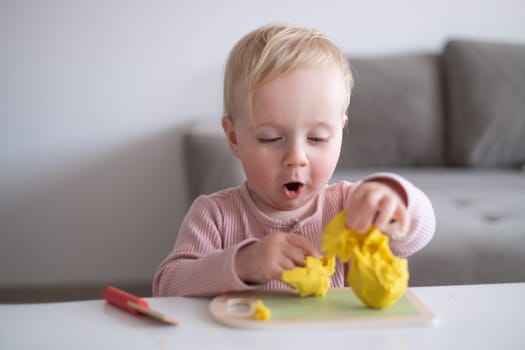 Portrait of smiling little toddler working with plasticine in art and craft class