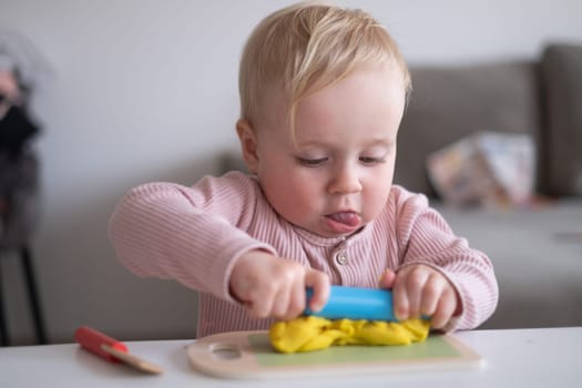 Portrait of smiling little toddler working with plasticine in art and craft class