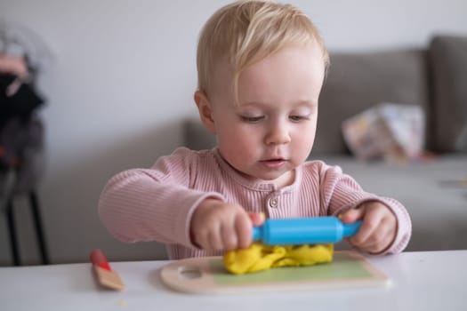 Portrait of smiling little toddler working with plasticine in art and craft class