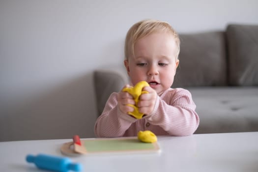 Portrait of smiling little toddler working with plasticine in art and craft class