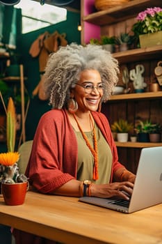 A happily retired African-American woman with gray hair works at her computer. High quality photo