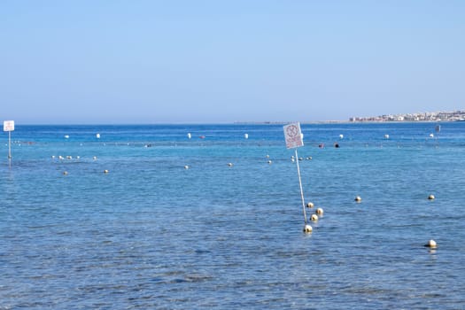 A clear blue sea with buoys and a distant shore, offering a tranquil and peaceful marine view.