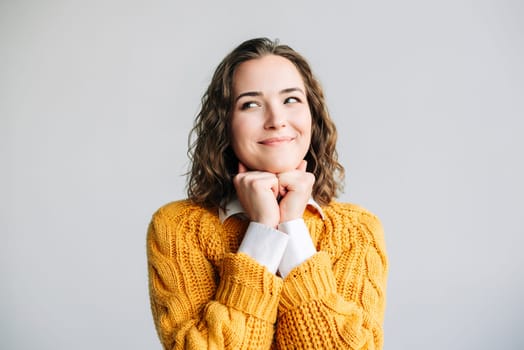 A cheerful young woman with a bright smile, resting her chin on her hands. Perfect for themes of happiness, positivity, and contemplation. Isolated on a white background, ideal for diverse uses.