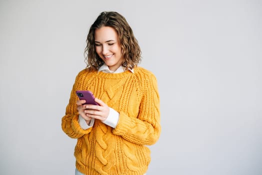 Young businesswoman, manager, or professional using her smartphone. She is engaged in corporate tasks, checking apps, and browsing online, showcasing technology in business.