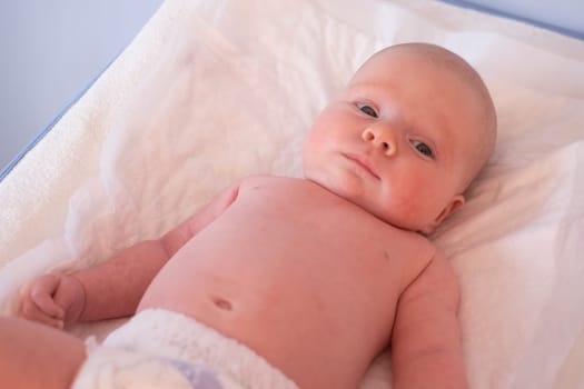 Cute small caucasian boy lying at bed looking at camera