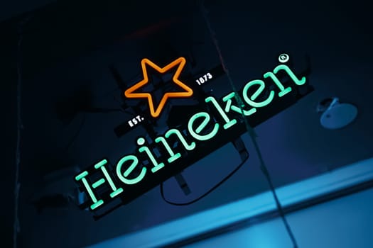 View of Heineken neon light sign at a pub. Heineken is a Dutch brewing company, founded in 1864 by Gerard Adriaan Heineken in Amsterdam. BISHKEK, KYRGYZ REPUBLIC - 25 JULY 2021