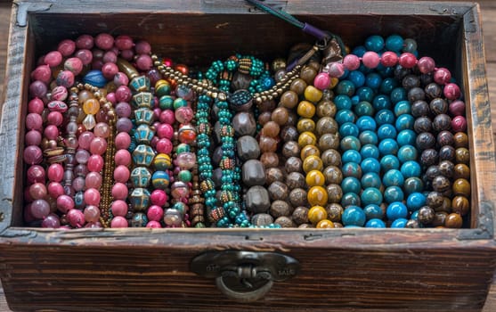 A detailed jewelry box displaying a collection of multicolored beads and intricate jewelry
