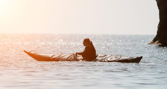 Happy smiling woman in kayak on ocean, paddling with wooden oar. Calm sea water and horizon in background